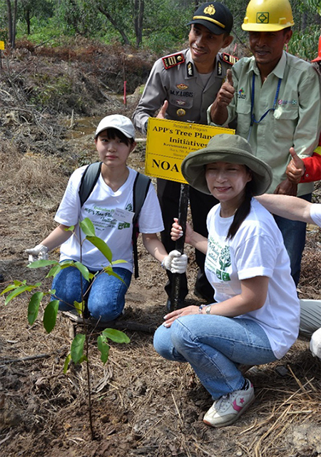 写真1：植樹イベントでフタバガキの苗木を植えたボランティアの母娘