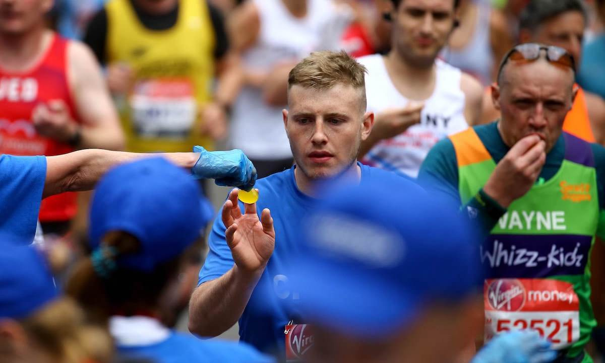 写真) Oohoで包装された飲料がロンドンマラソンのランナーに手渡される様子