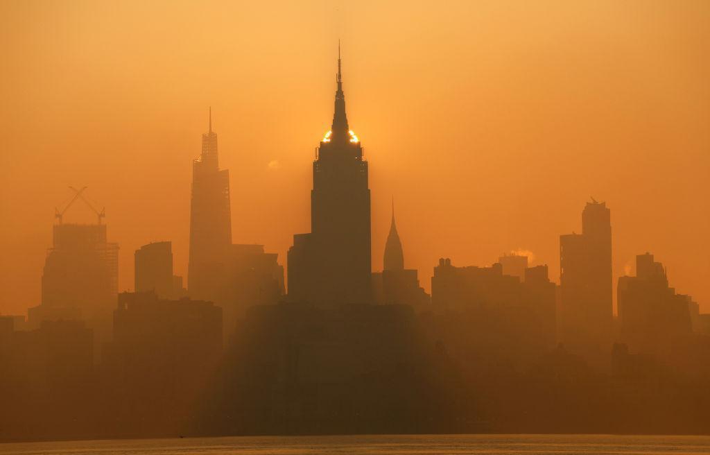 写真）ニュージャージー州から見たニューヨーク市のエンパイアステートビルなど高層ビル群。カナダの森林火災に起因する煙害で市は大気汚染警報を発出した。2023年7月5日、ニュージャージー州ジャージーシティ