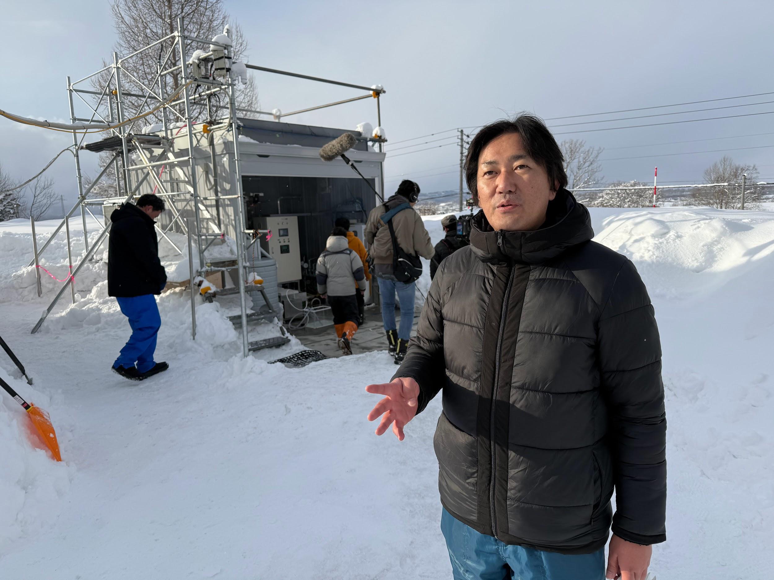 写真）施設の前で説明する榎木光治准教授