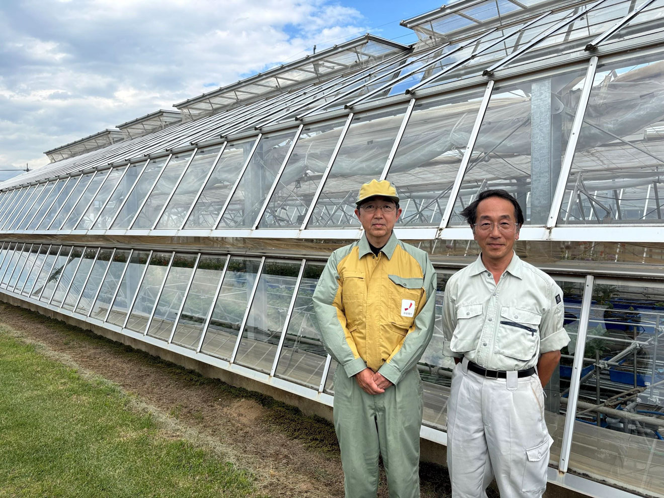 写真）ハウスの前に立つ長野県野菜花き試験場の専門研究員、神谷勝己氏（右）と中部電力株式会社電力技術研究所の研究主査、鈴村素弘氏（左）